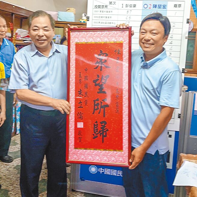 新竹县芎林乡县议员补选1日顺利投开票，国民党新竹县党部主委陈见贤（左）致赠「眾望所归」匾额，祝贺陈星宏（右）当选县议员。（罗浚滨摄）