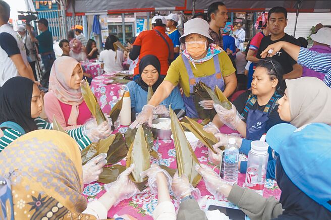 2024屏东好客米食节1日在佳冬老街举行，屏科大来自印尼的学生也前来体验包粽子文化。（罗琦文摄）