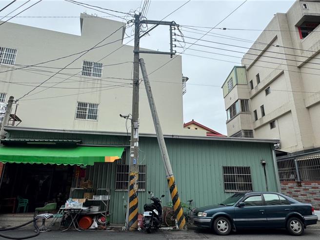 台中市大里区元正路1处路口，1支电杆正常直立，另1支却倾斜了约30度倒在直立的电杆上，民眾担心受地震、颱风影响倒塌危及安全。（潘虹恩摄）