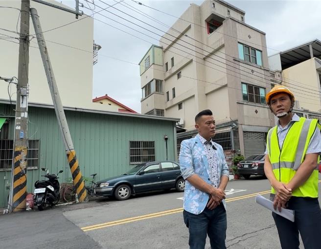 台中市大里区元正路1处路口，1支电杆倾斜约30度倒在另1支电线杆上，引发民眾担心倒塌，台中市议员江和树（左）3日邀集台电人员前往了解情况。（潘虹恩摄）