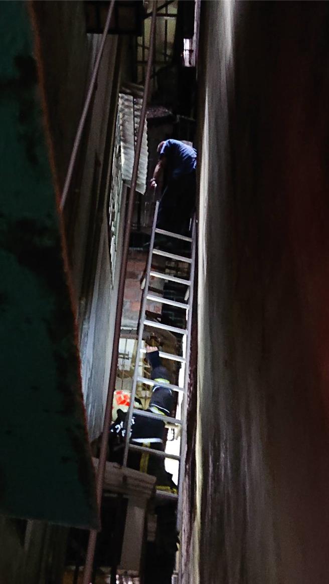 嫌犯原想跳窗脱逃，结果卡在防火巷，警方通知消防人员前来协助救援。（国道公路警察局提供）