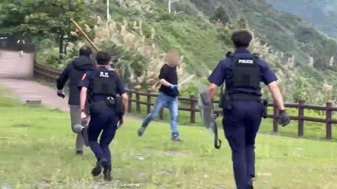 男子持刀與警方僵持，不斷威脅警方不敢大意。（翻攝畫面）