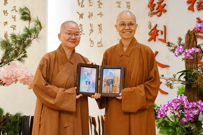 觉居法师 (右) 致赠讲座纪念照片给主讲人如常法师(左) 。(图/佛光山惠中寺提供)