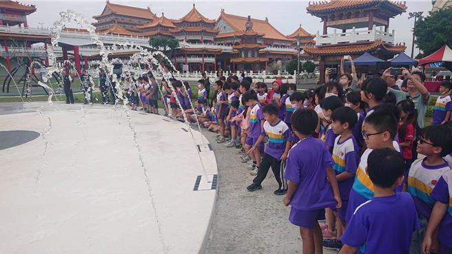 正统鹿耳门圣母庙的庙徽公园戏水池3日启用喷水，儿童见状十分兴奋。（程炳璋摄）