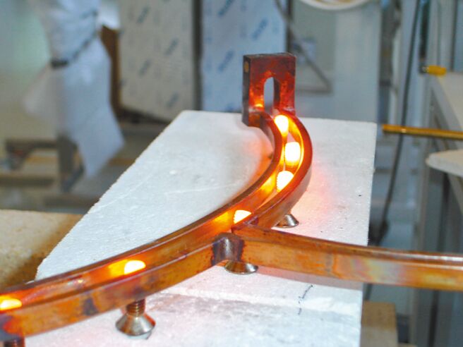 高周波感应螺丝局部热处理，通过隧道式线圈连续加热。图／业者提供