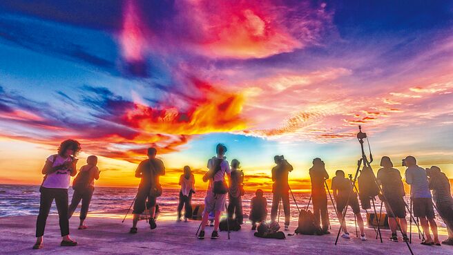 新丰乡凤坑沙湾有2道像「红豆饼」的防波堤，落日彩霞美景吸引很多游客拍照打卡。（罗浚滨摄）