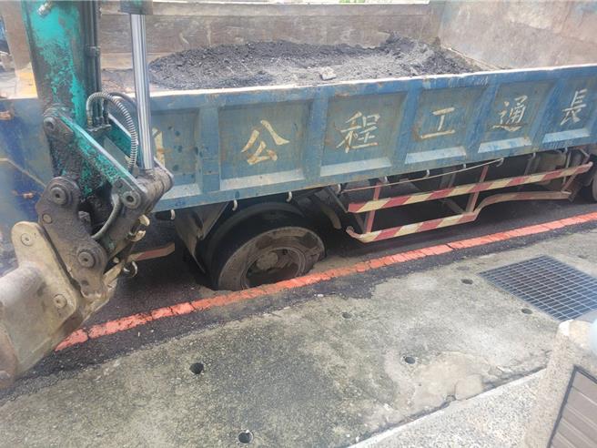 台中大里十九甲地區近日自來水水壓異常，經報請水公司派員尋找漏水點，5日水公司施工小貨車行經大里立中六街81號前時右後輪竟陷入坑洞動彈不得。（江和樹提供／馮惠宜台中傳真）
