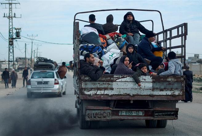 一輛駛離拉法的卡車，難民的臉龐寫滿無奈與無助。（圖／路透社）