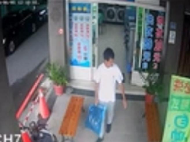 警方调查发现，1名穿着白色上衣的男子潜入自助洗衣店将已烘乾的整袋袜子偷走。（民眾提供／孙英哲彰化传真）