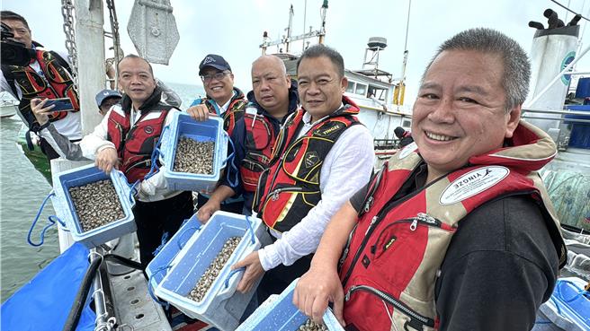 金門縣副縣長李文良(左二)與縣議員陳泱瑚(左一)、陳錦偉(中)、張雲量(右二)及洪鴻斌(右一)，率先將一箱箱的鳳螺苗放流入海。(于家麒攝)