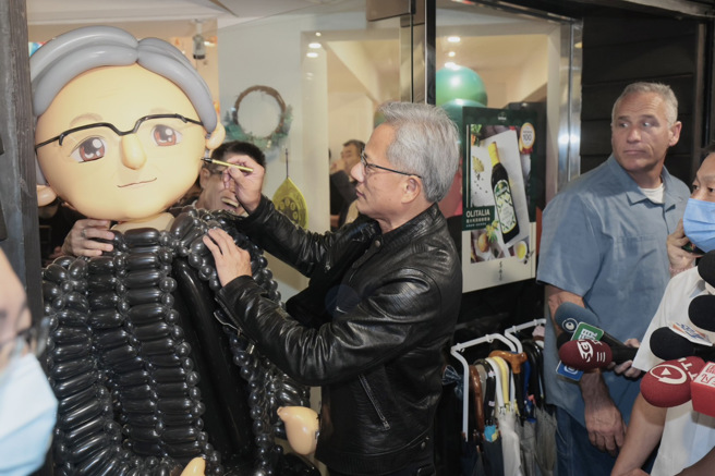 廣達集團創辦人林百里5日晚間作東邀請輝達執行長黃仁勳（中）餐敘，黃搬出廣達特別訂製的人形氣球，在媒體前亮相並簽名。（資料照片/郭吉銓攝）