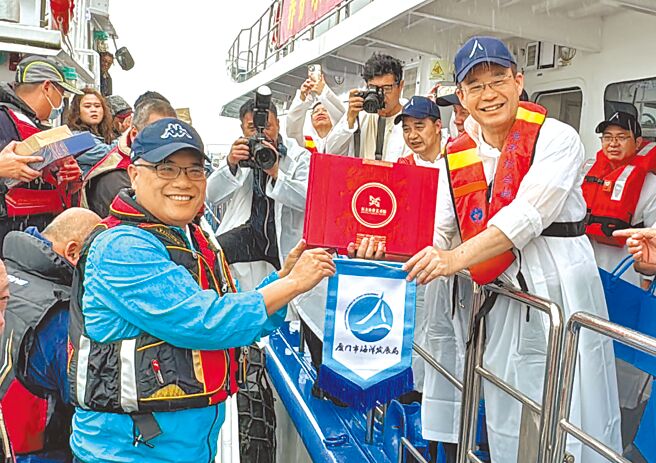 金門縣副縣長李文良（左）與廈門市海洋發展局長曾東生（右）交換贈禮後，雙方開始放流魚苗。（于家麒攝）