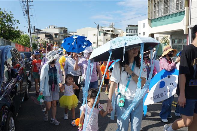 東光附幼童老師扮成水母，笑稱「一兼二顧」遮陽擋雨。（羅琦文攝）