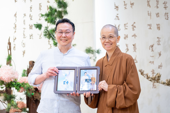 觉居法师 (右) 致赠讲座纪念照片给主讲人黄国珍(左) 。(图/佛光山惠中寺提供)