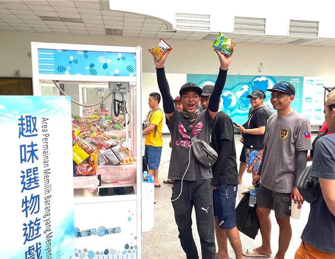 高雄市海洋局於6月7日在前鎮「高雄市漁民服務中心」舉辦外籍船員關懷活動，一名外籍移工在趣味選物遊戲中獲得獎品，舉臂歡呼。（高雄市海洋局提供／林瑞益高雄傳真）