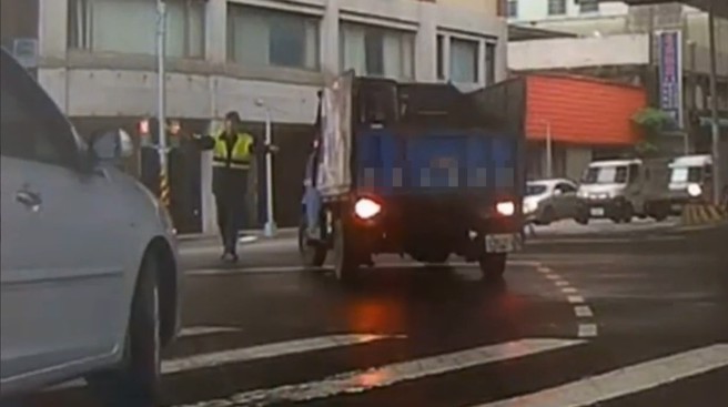 小貨車闖黃燈要左轉，差點撞到指揮交通的警員。（翻攝爆料公社）