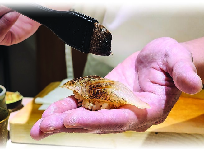 表面帶有炭火焦香的〈炙燒紅喉握壽司〉，有主廚特製醬汁提味。圖／姚舜