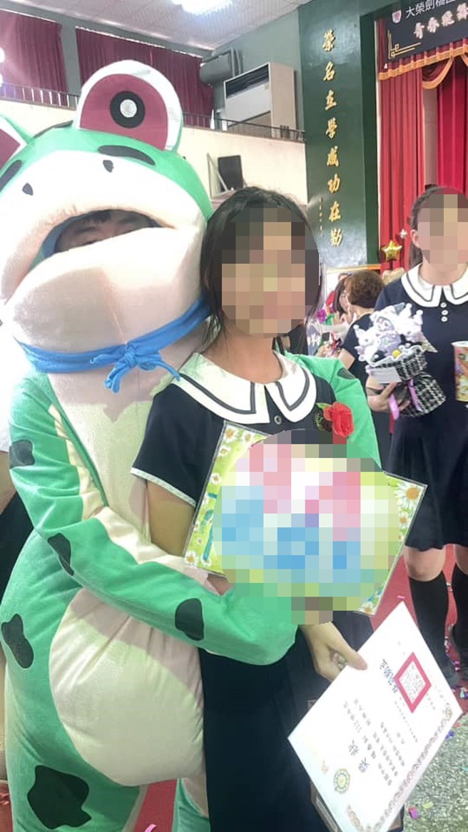 一名父亲在女儿在国中毕业典礼这天，穿青蛙装去参加，两人的合照。（翻摄爆废1公社）