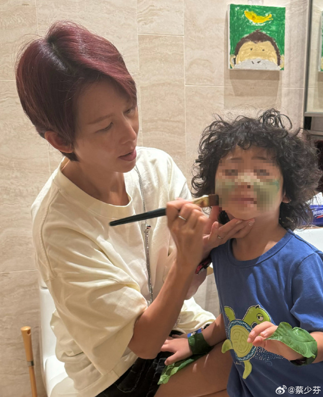 蔡少芬帮儿子脸上涂色。（图/翻摄自蔡少芬微博）