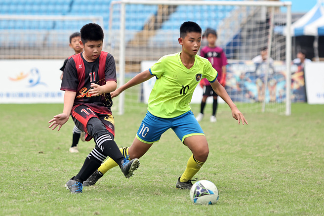 台中協和國小10號洪世衡(右)努力盤球推進。（迷你足球協會提供）