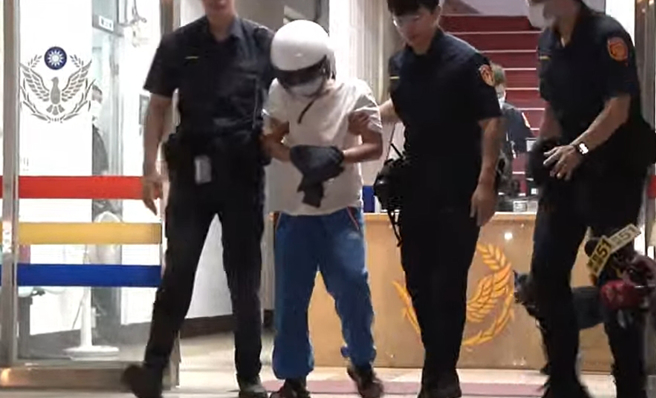 陳姓嫌犯被警方帶上警車，前往分局拘留室。（翻攝畫面）