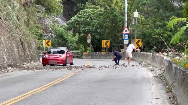 今天是端午連假最後一天，蘇花路廊全線順暢，163.4公里處下午卻突然發生落石，大小石塊散落在道路上，經路過民眾與員警合力排除，警方現在也在現場以雙線單向引導車流前行。（新城警分局提供／羅亦晽花蓮傳真）