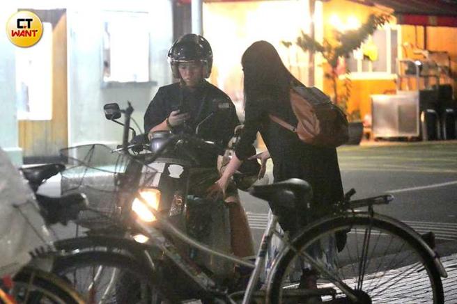 李屏瑶将安全帽交给连俞涵，但视线完全没离开过手机。（图／本刊摄影组）