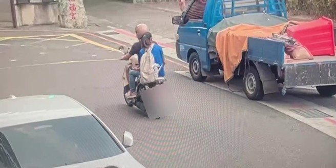 男子騎乘機車，載著一名女子經過理髮店外。（翻攝畫面）