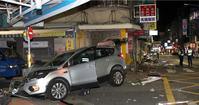 张男驾车连撞7店面，巨大的声响惊醒许多住户，纷纷跑下楼查看，现场满目疮痍。（黄世麒摄）