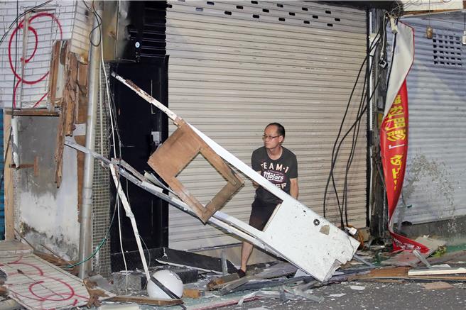 张男驾车连撞7店面，店家在现场收拾处理。（黄世麒摄）