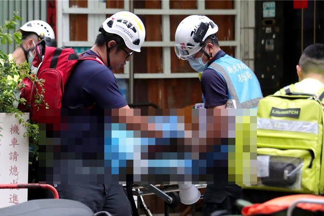 消防员找到受困的住户，但已无生命迹象，紧急送往医院抢救。（黄世麒摄）