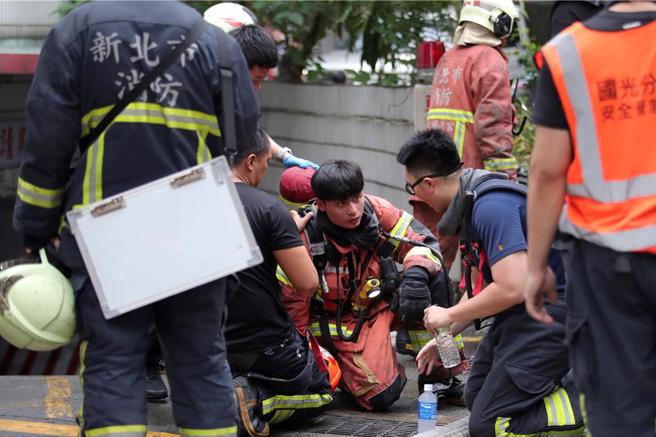 1名消防员在抢救过程中身体不适，被同僚紧急送往医院。（黄世麒摄）