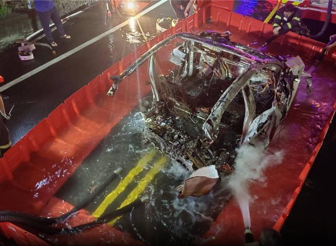 國道1號虎尾段日前發生一起特斯拉墜落邊坡起火，雲林縣消防局前往滅火但無法撲滅，緊急向縣府水利處商界擋水板圍成水池降溫才滅火。（民眾提供）