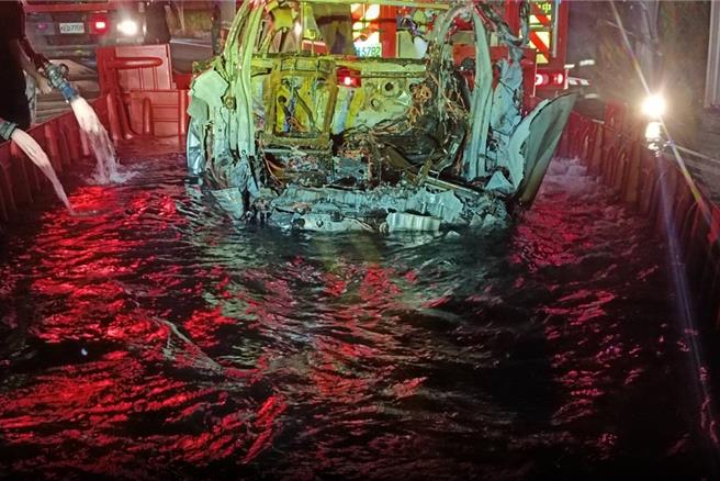 國道1號虎尾段日前發生一起特斯拉墜落邊坡起火，雲林縣消防局前往滅火但無法撲滅，緊急向縣府水利處商界擋水板圍成水池降溫才滅火。（民眾提供）