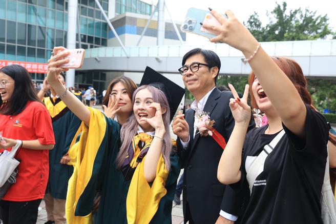 陈其迈与毕业生欢乐合影，为人生里程转捩点留下难忘回忆。（图片来源：高雄市政府提供）