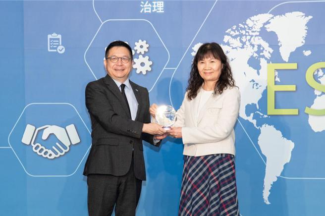 上银科技资深副总经理吴月琴从证交所董事长林修铭接下公司治理评鑑前5％奖座的殊荣。图／上银科技提供