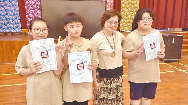 南投縣港源國小校長梅文慧（右二）12日頒發畢業證書給3名學生盧品瑄、黃凱威、黃瑋凌，她送走末代畢業生，學校也即將走入歷史。（楊靜茹攝）