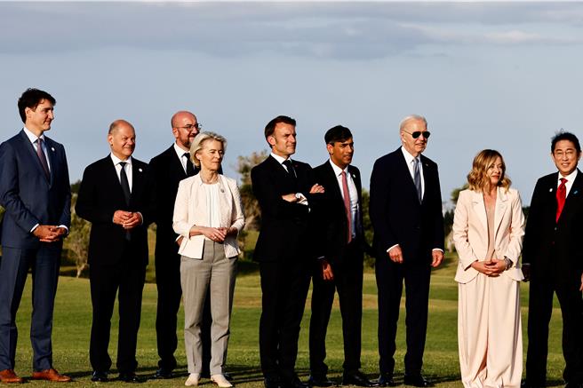 图为G7领袖在观看降落伞表演后合影。（路透社）
