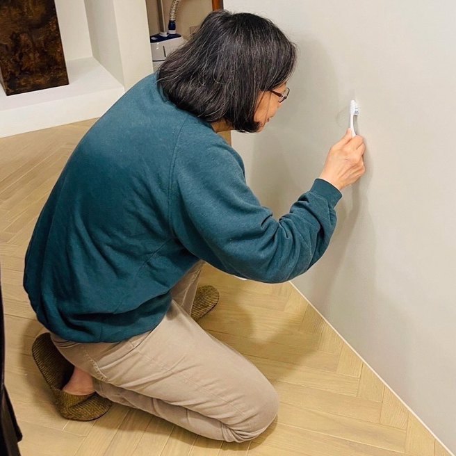 前總統蔡英文曬出蹲在地上處理牆面的居家照。（翻攝自蔡英文Threads）