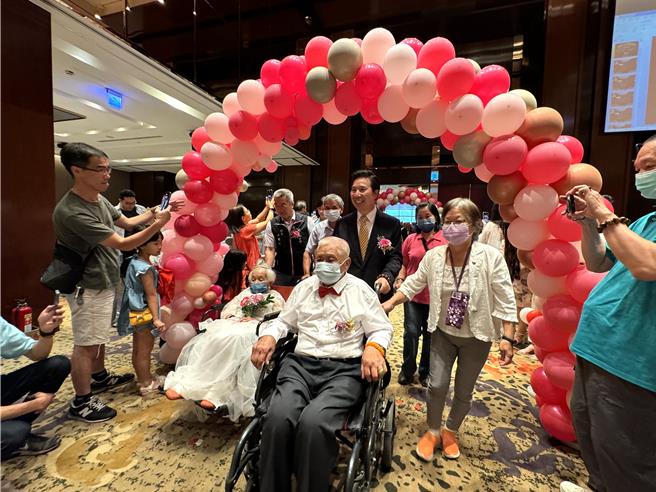 2024金门金钻婚表扬活动今日上午假金湖饭店隆重登场，县长陈福海（二排中）亲自在充满喜气的气球拱门前一一迎接62对金钻婚夫妻。（于家麒摄）