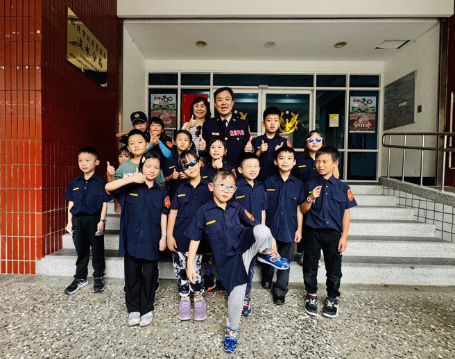 淡水警分局長彭正中與小小警察們在分局前開心合影，一同大喊：「警察節快樂！揪咪！」（圖 / 警方提供）