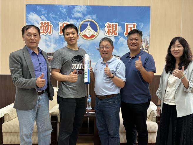 東京奧運羽球金牌選手李洋(左二)今日在父親李峻淯(左一)的陪同下返回家鄉金門，並捐贈YONEX羽毛球200筒予縣府代為轉發各級學校，以回饋家鄉並支持年輕學子的體育夢想。(于家麒攝)