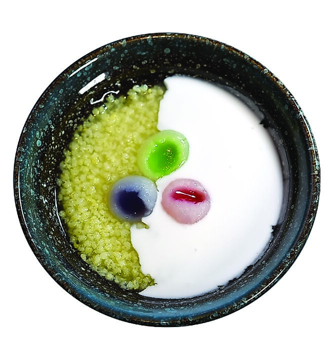 〈龙眼椰香小米粥〉将小米熬成浓稠甜粥，并以椰奶提味添香，搭配用斑兰叶、蝶豆花染色的龙眼肉呈现。图／姚舜