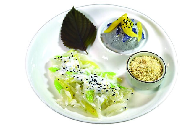 〈椰丝手指糯米卷〉是如今非常少见的传统泰式甜点，将糯米粉、在来米粉与葛粉混合成麵糰，再逐一以手工搓成细长的「指型」，撒上椰子丝、椰奶及白芝麻点缀，搭配黑芝麻冰淇淋呈盘。图／姚舜