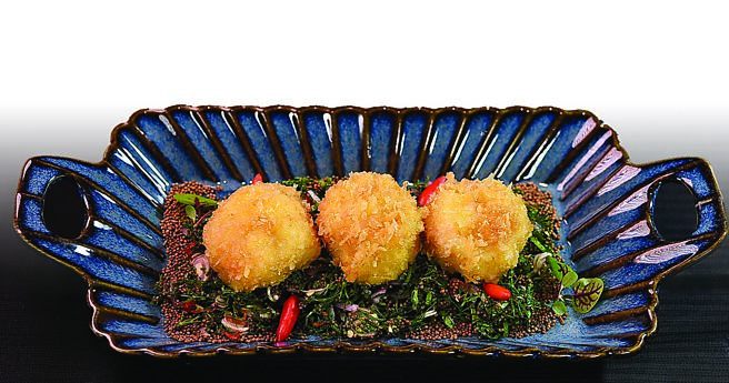 〈泰式香草紫苏籽干贝沙拉〉是将鲜甜柔嫩的大干贝裹麵衣油炸，盘底衬着用辣椒、香茅、洋葱、紫苏籽、香菜及鱼露、柠檬汁调制而成的特色沙拉。图／姚舜