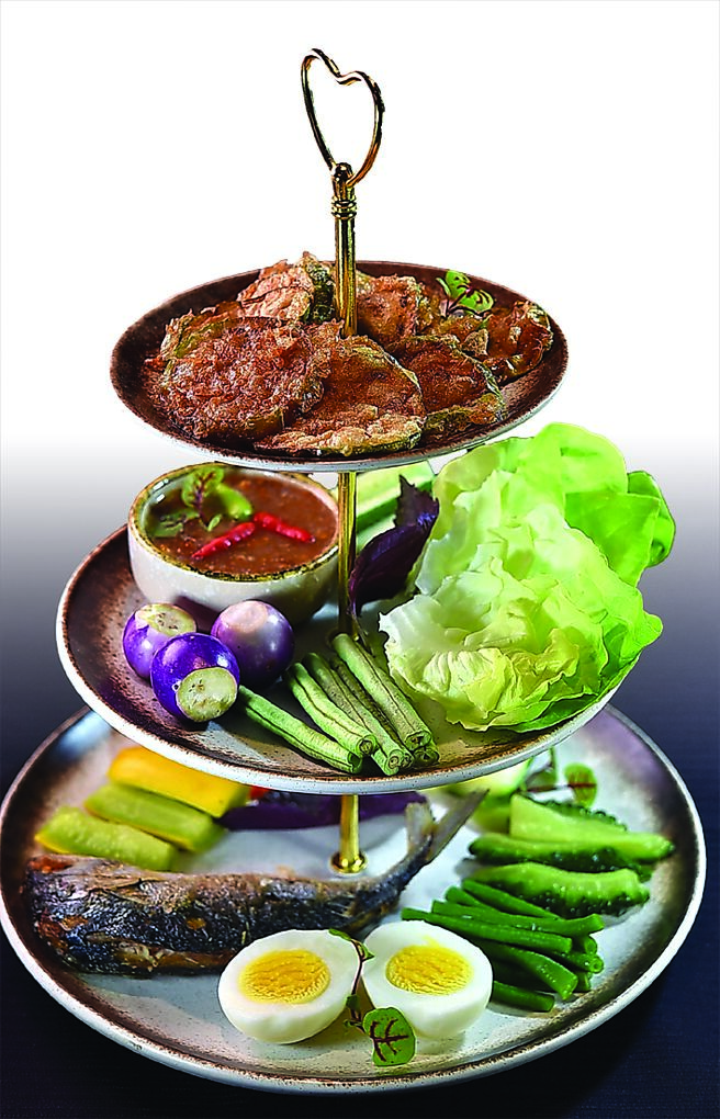 〈香酥鲭鱼鲜蔬蟹膏塔〉为源于拉玛五世朱拉隆功国王时期的皇家美食「Miang Pla Too」，最上层是炸茄子，中层有奶油莴苣、长豆、小黄瓜、小紫茄，下层有鸡蛋、苦瓜、栉瓜和炸鲭鱼。图／姚舜