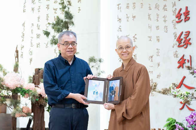 觉居法师（右）致赠讲座纪念照片给讲师杨照（左）。(图/佛光山惠中寺提供)