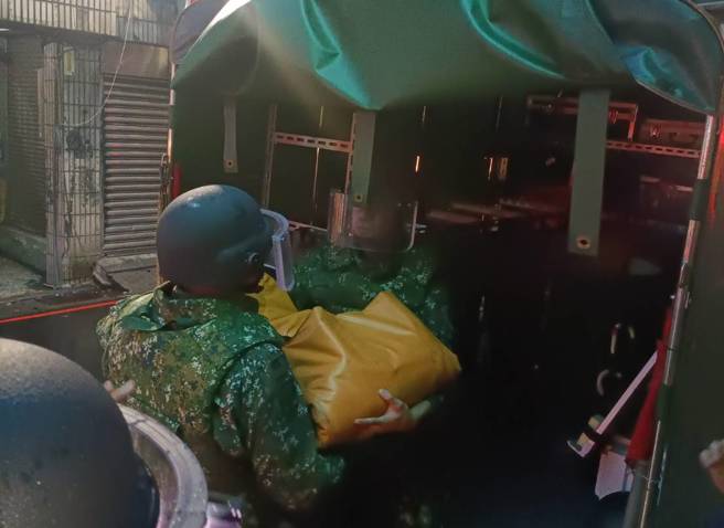 军方到场后以防爆毯包裹未爆弹，小心翼翼搬上车。（图 / 刘咏韵翻摄）