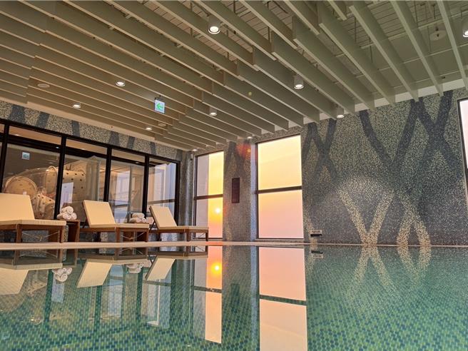 长达20公尺的温水泳池是饭店必拍必玩的亮点，因为泳池位处高楼层，加上大面积的落地窗引进大量自然光，如梦似幻。(嘉义福容voco酒店提供)