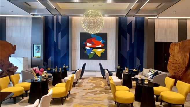 「嘉义福容voco」巧妙融入吉祥物设计，酒店内许多地方都可看到吉祥物的图样或周边，像是大厅的燕雀画作与柜台的燕雀logo。(陈韵萍摄)